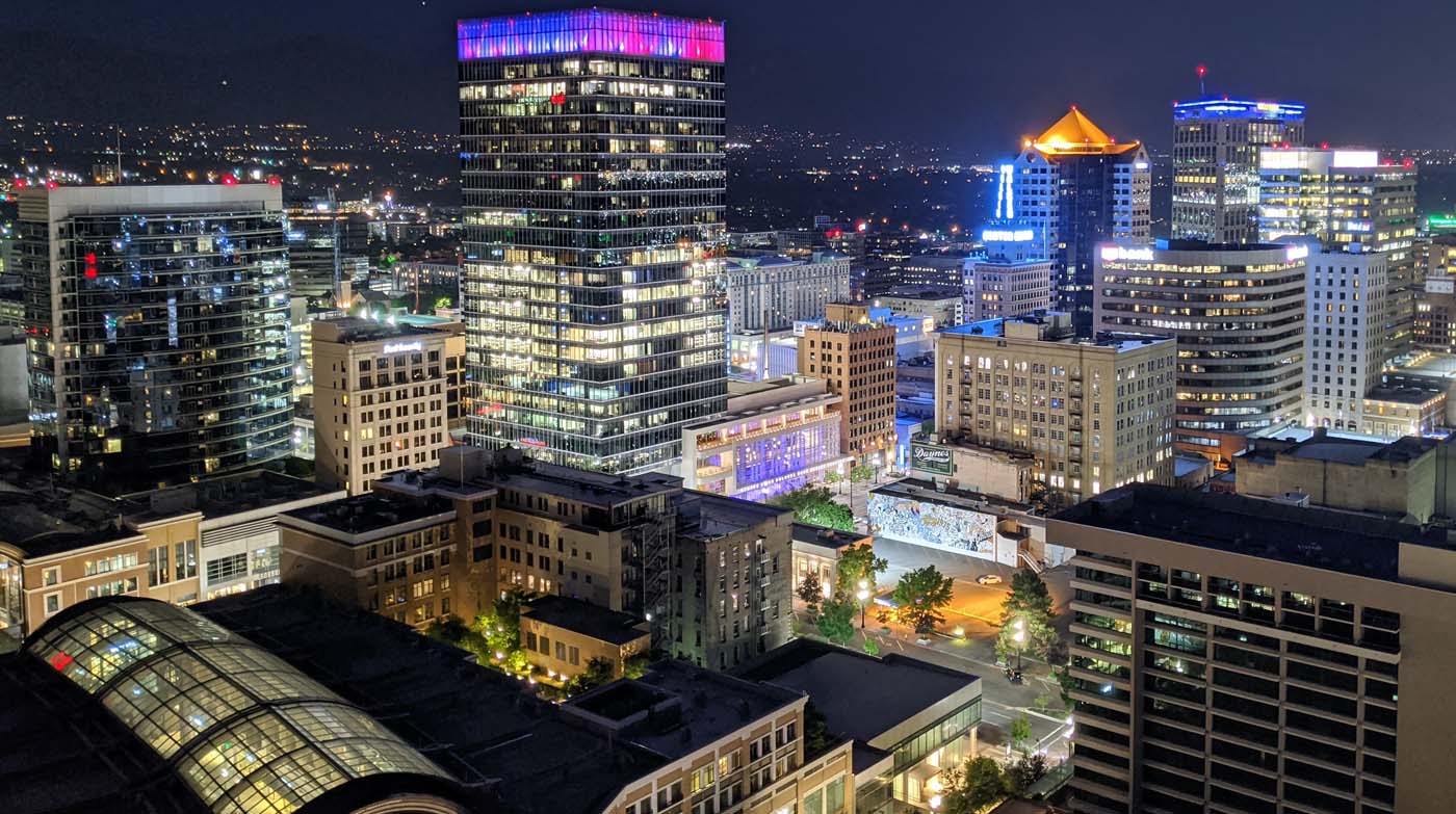 night aerial view across downtown salt lake city commercial real estate utah skyline of office buildings with their lights on under a black sky