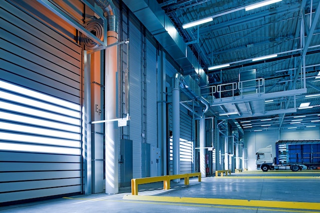 inside a warehouse industrial space with closed roller doors and truck in background at offices.net