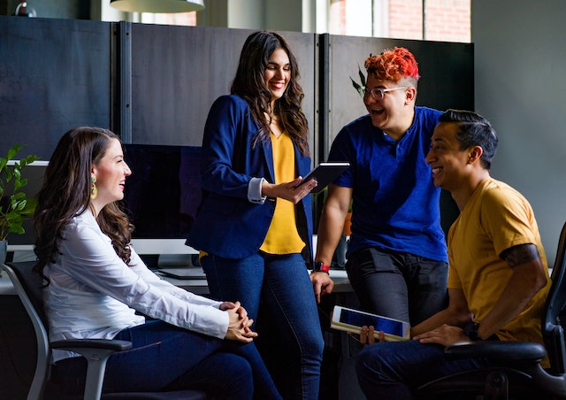 group of co-workers have an enjoyable discussion holding tablets image at offices.net