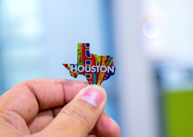 colorful houston texas state pin being held by man's hand image at offices.net