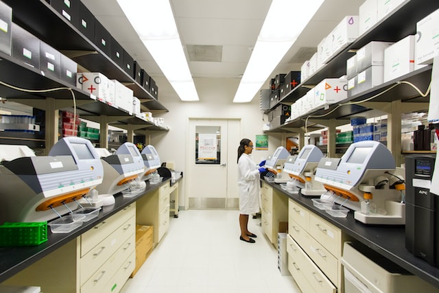 woman in white lab coat working in a life sciences sector lab image at offices.net