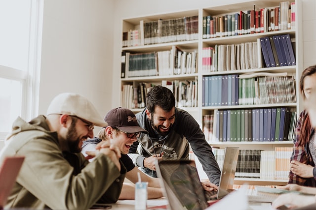 group of students laughing and working at a coworking space for students on a u.s. college campus image at offices.net