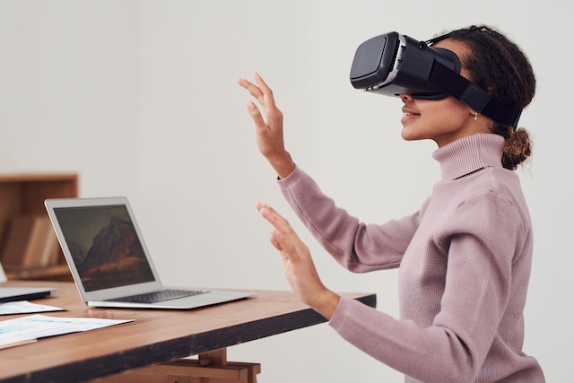 a woman sitting at her desk working whilst wearing a VR headset