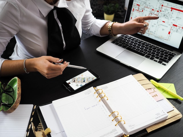 real estate professional sitting at their desk and pointing at market data that appears on their laptop