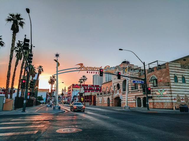 ground view of palm tree and building lined street in las vegas with sun on the distant horizon image at offices.net 