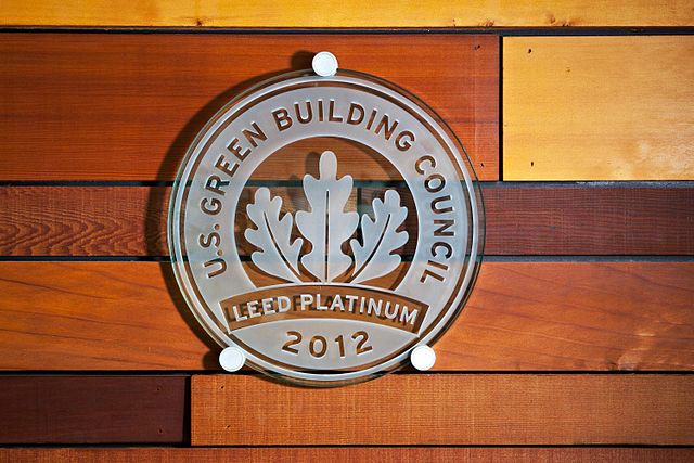 a close up of a united states green building council leed platinum 2012 certification emblem affixed to a wooden wall image at offices.net