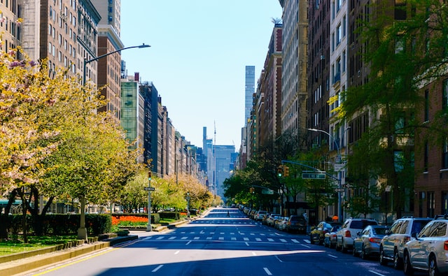 a daytime view down an urban apartment lined street with tall office buildings in the distance image at offices.net