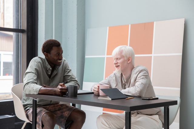 co-workers having discussion in front of pastel and muted colors in the workplace image at offices.net