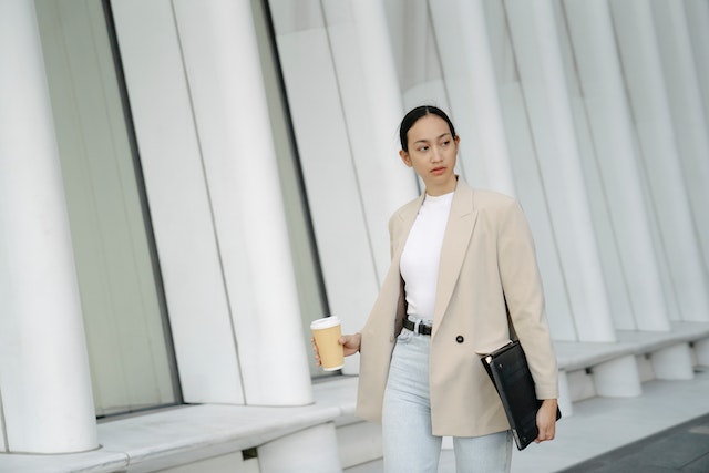 millennial walking through an office holding a coffee 