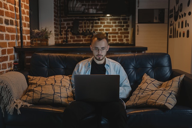 man sitting on couch with laptop