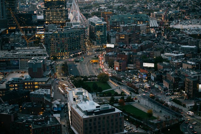 A nighttime aerial view down on Boston’s bustling CBD. Image at Offices.net.